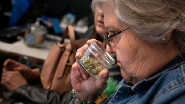 Juree Burgett, who traveled from Kansas, smells various varieties of cannabis at a dispensary in Kansas City, Missouri -- a state where recreational pot use is now legal