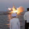This undated picture released from North Korea's official Korean Central News Agency (KCNA) on August 21, 2023 shows North Korea's leader Kim Jong Un (R) watching a strategic cruise missile being launched from a ship