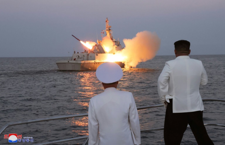 This undated picture released from North Korea's official Korean Central News Agency (KCNA) on August 21, 2023 shows North Korea's leader Kim Jong Un (R) watching a strategic cruise missile being launched from a ship