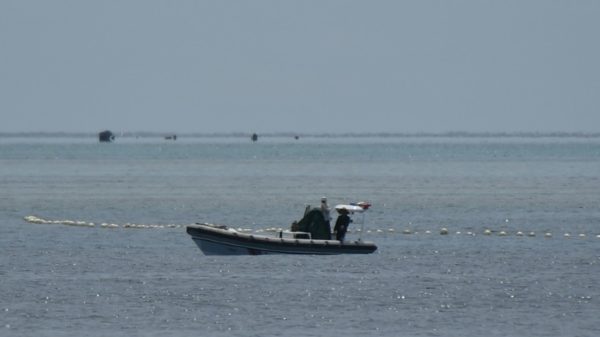 Chinese coast guard patrol the Scarborough Shoal beside a floating barrier