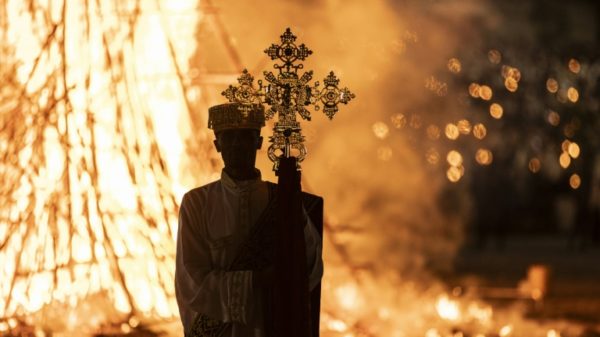 A high priest holds a cross while standing in front of a bonfire during the Meskel celebrations in Addis Ababa