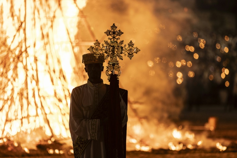 A high priest holds a cross while standing in front of a bonfire during the Meskel celebrations in Addis Ababa