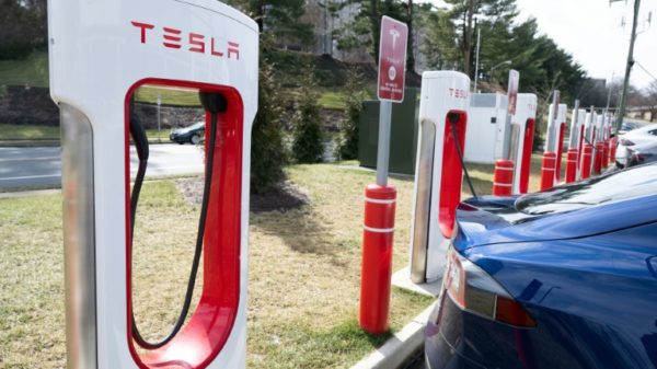 The embrace of Tesla's electric vehicle charging network has raised questions about whether it will supplant a rival system and become the national standard