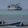Chinese coast guard boats intercept Filipino fisherman Arnel Satam (R) as he tries to enter Scarborough Shoal in disputed waters of the South China Sea