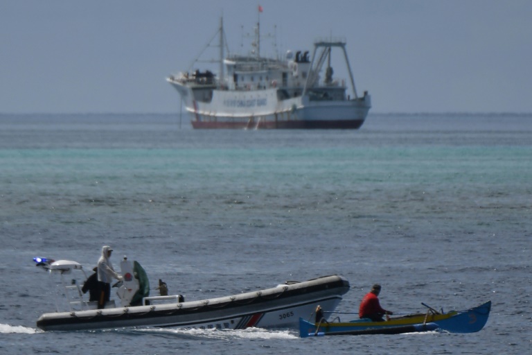 Chinese coast guard boats intercept Filipino fisherman Arnel Satam (R) as he tries to enter Scarborough Shoal in disputed waters of the South China Sea