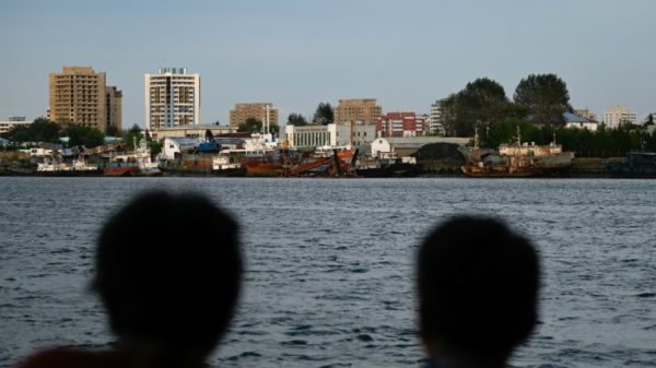 Chinese tourists watch the North Korean border on the Yalu river in the Chinese border town of Dandong