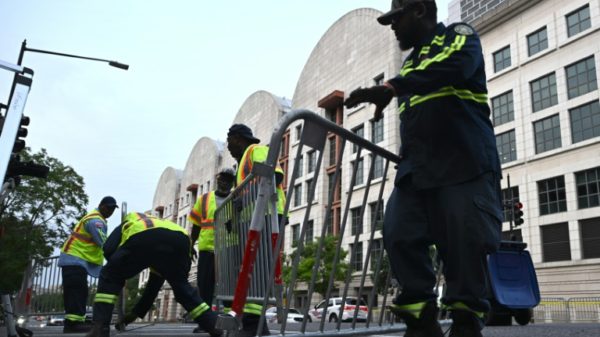 Workers set up barricades before the arrival of former US president Donald Trump for arraignment at the E. Barrett Prettyman US States Courthouse in Washington, DC on August 3, 2023