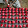 In this photograph taken on September 14, 2023, a worker polishes cricket balls at a workshop in Meerut in India's northern state of Uttar Pradesh