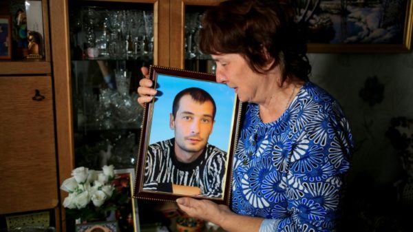 Galina Inkina cries holding a portrait of her late son, Denis, killed in a Kazakh mine