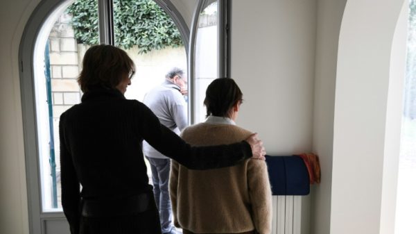 A carer helps an elderly resident - one of three alzheimer sufferers in the establishment- in a house at L'Hay-les- Roses on the outskirts of Paris