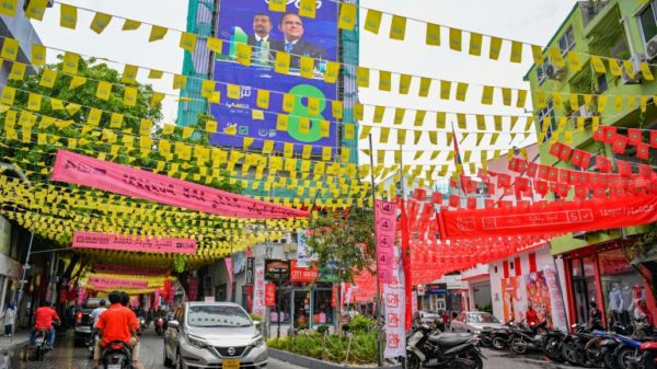 Commuters in the Maldives make their way along a street decorated ahead of the country's presidential election